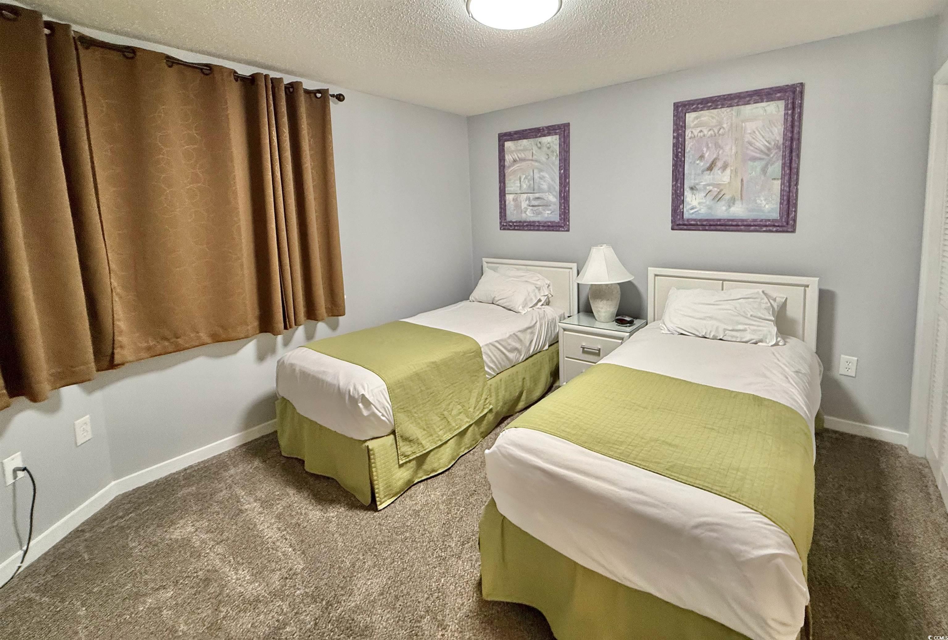 410 Melrose Place, Unit 310 Myrtle Beach, SC 29572 - Photo 32 of 39 Carpeted bedroom with a textured ceiling and baseboards