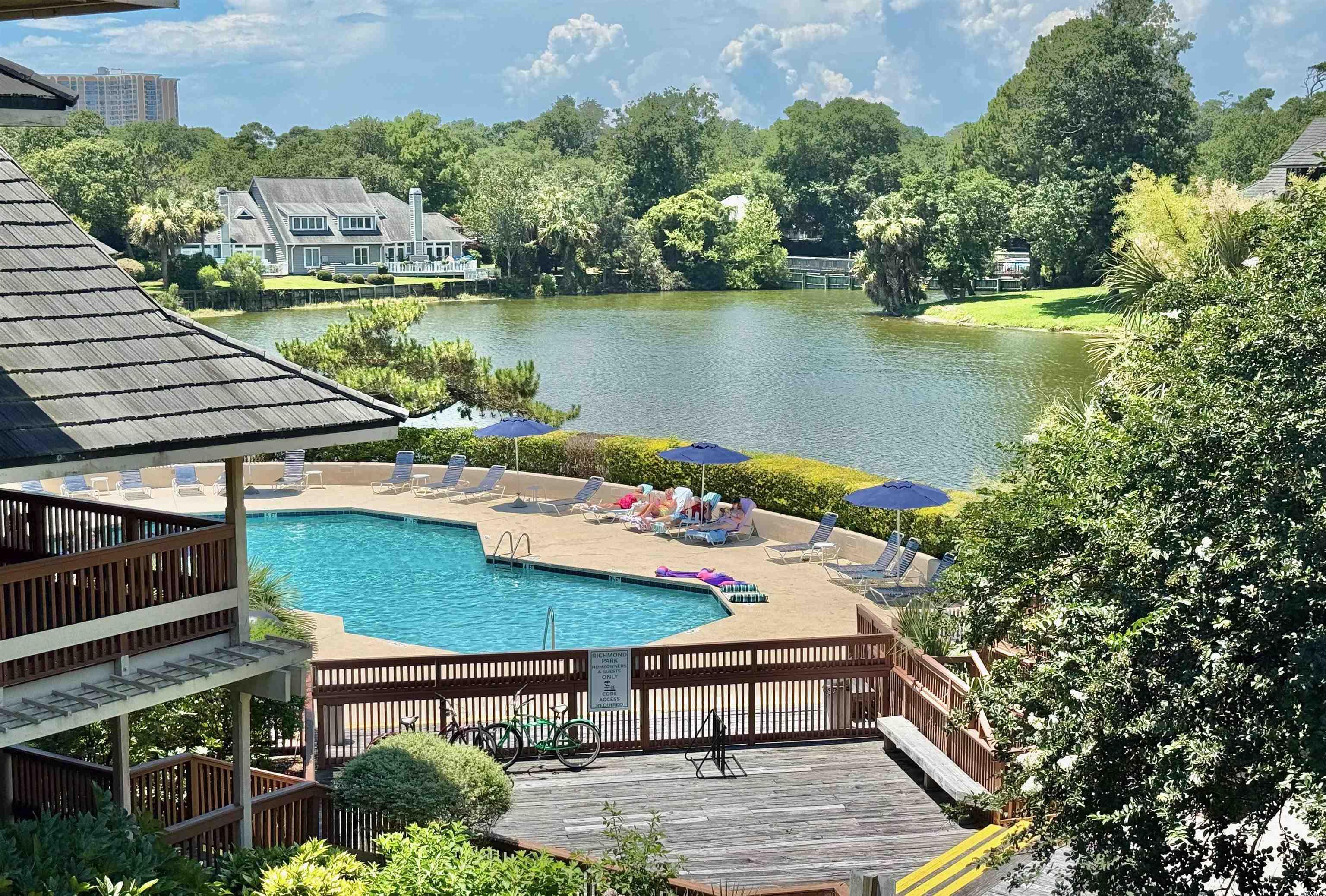 410 Melrose Place, Unit 310 Myrtle Beach, SC 29572 - Photo 39 of 39 Community pool featuring a patio, a deck with water view, and view of scattered trees