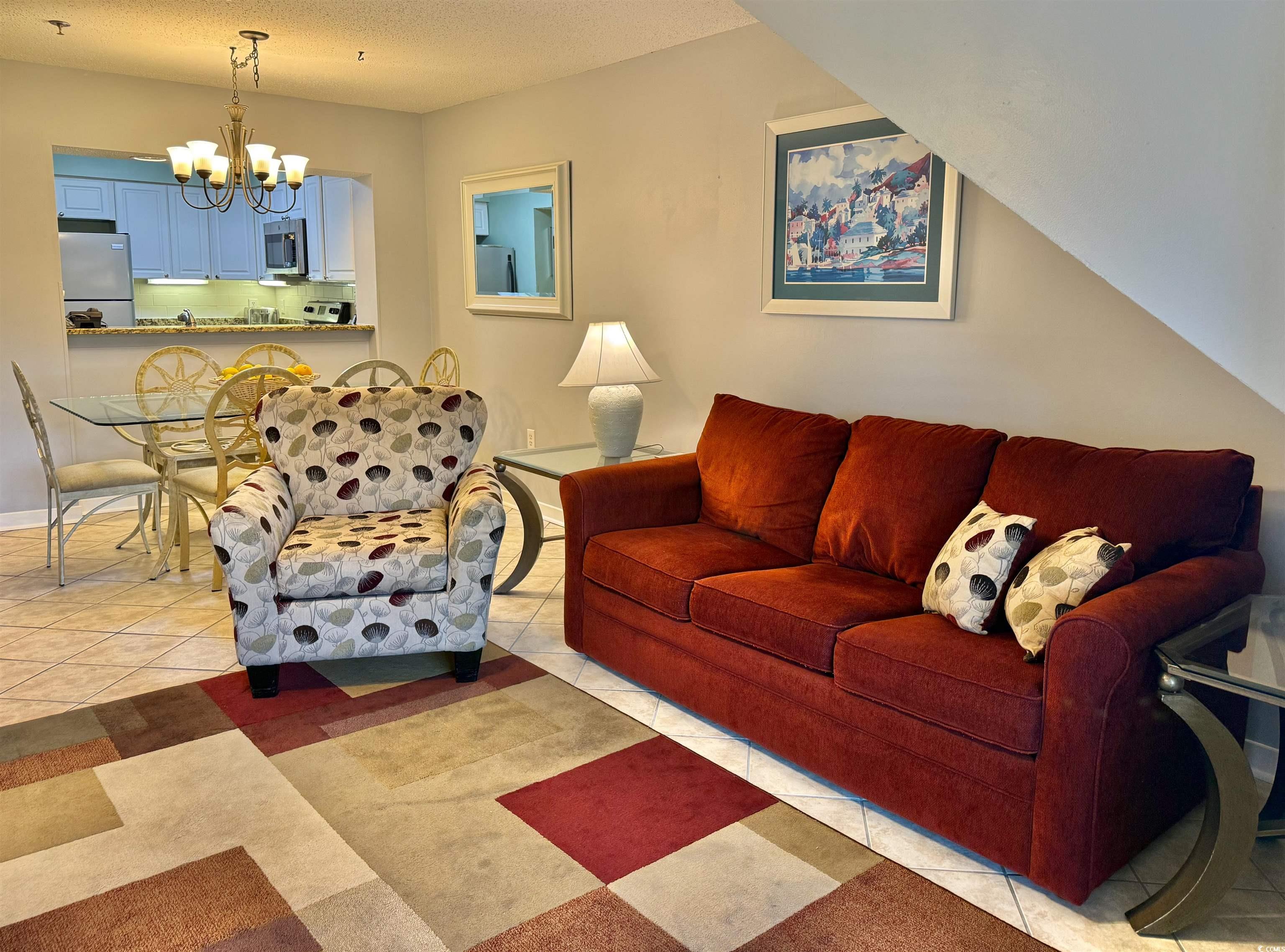410 Melrose Place, Unit 310 Myrtle Beach, SC 29572 - Photo 5 of 39 Living area with light tile patterned flooring, a textured ceiling, and a chandelier