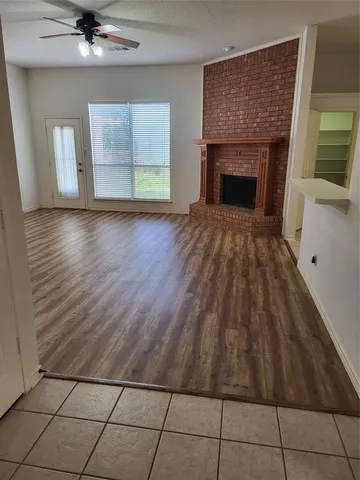 a view of a livingroom with wooden floor and a fireplace