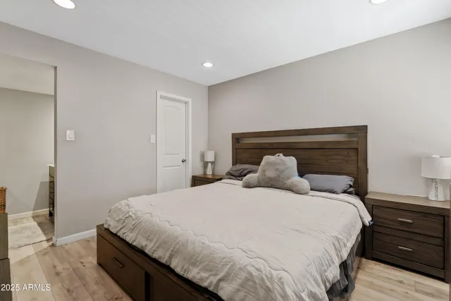 a bedroom with a bed and wooden floor