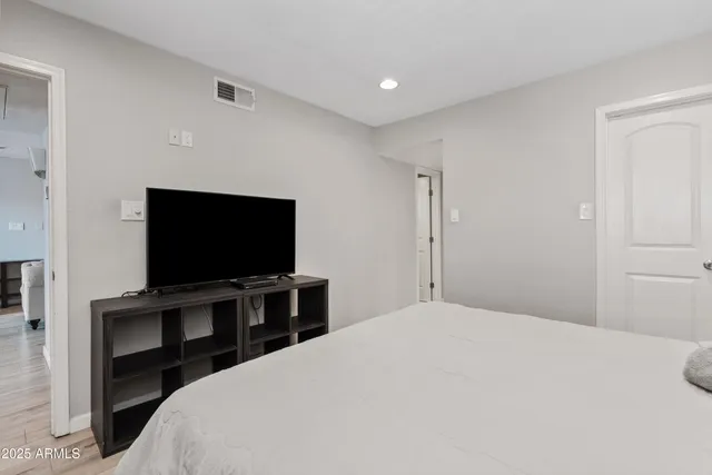 a bedroom with a bed and a flat screen tv