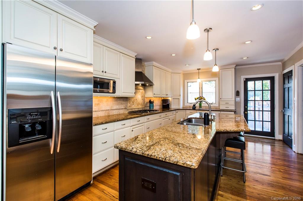 2307 Overhill Road Charlotte, NC 28211 - Photo 4 of 24 a kitchen with stainless steel appliances granite countertop a refrigerator a stove and a sink with wooden floor