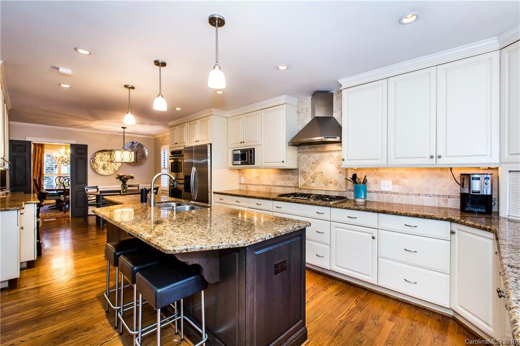 2307 Overhill Road Charlotte, NC 28211 - Photo 6 of 24 a kitchen with stainless steel appliances granite countertop a stove top oven a sink dishwasher and white cabinets with wooden floor