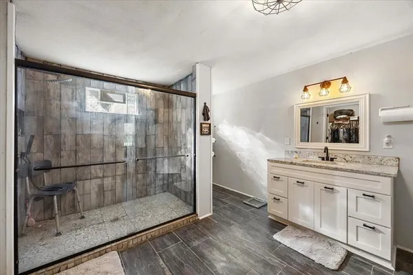a bathroom with a double vanity sink mirror and shower