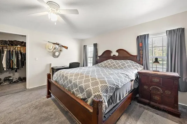 a bed sitting in a spacious bedroom next to a window