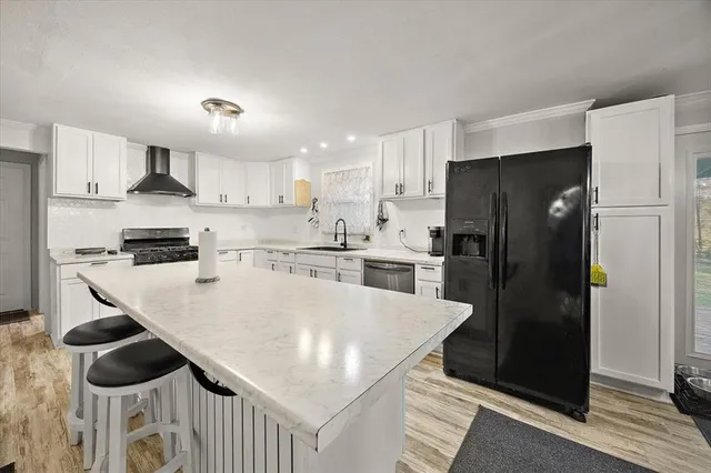 a kitchen with stainless steel appliances granite countertop a refrigerator a stove and a refrigerator