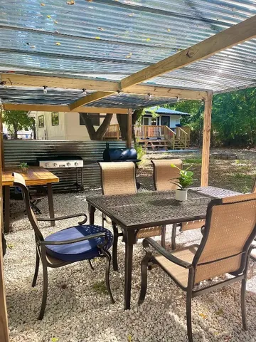 a patio with glass top table and chairs