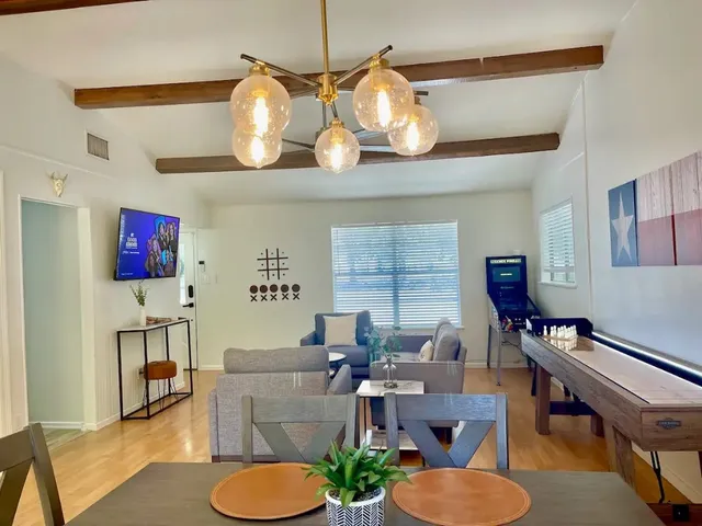 a living room with furniture kitchen view and a window