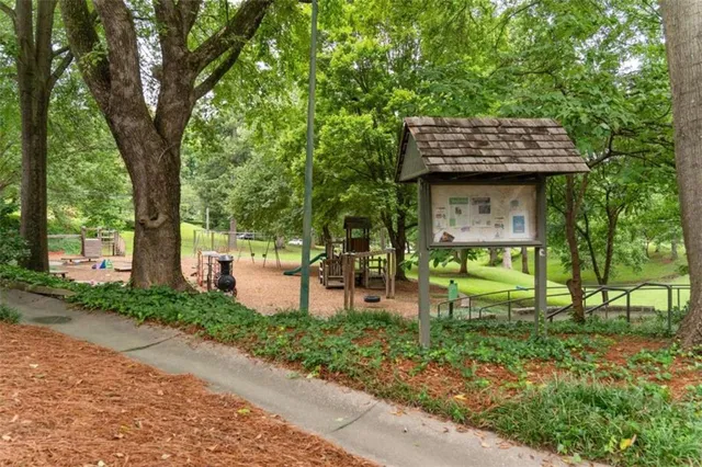 a sign board with a yard in the back