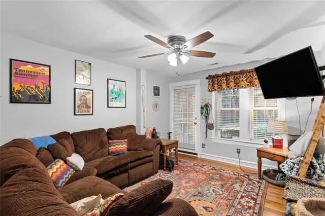 a living room with furniture a flat screen tv and a window