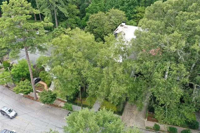 an aerial view of a house with a yard and tree s