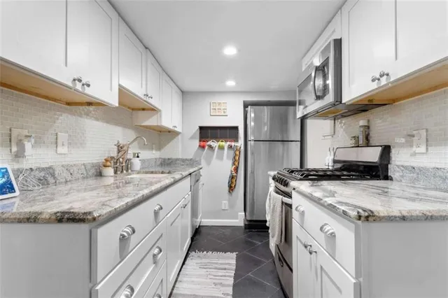 a kitchen with stainless steel appliances granite countertop a sink stove and refrigerator