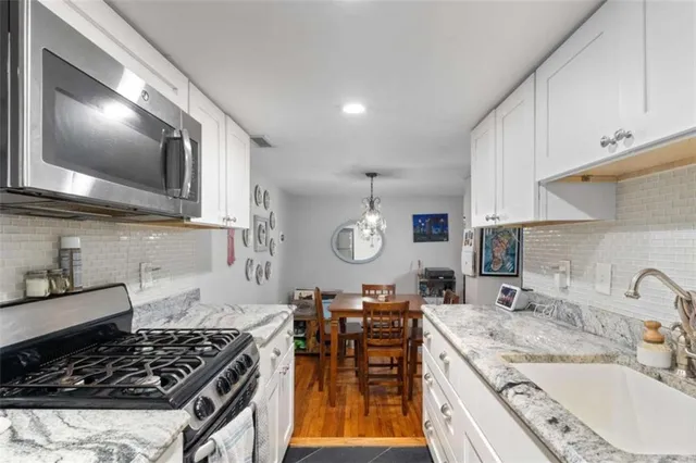 a kitchen with stainless steel appliances granite countertop a sink stove and cabinets