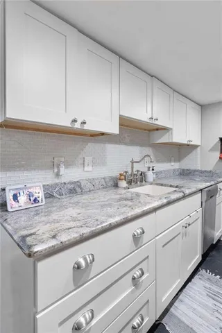a kitchen with granite countertop a sink and cabinets