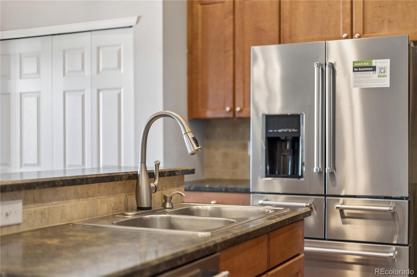 5031 South Rome Street Aurora, CO 80015 - Photo 12 of 39 a kitchen with stainless steel appliances granite countertop a refrigerator and a sink