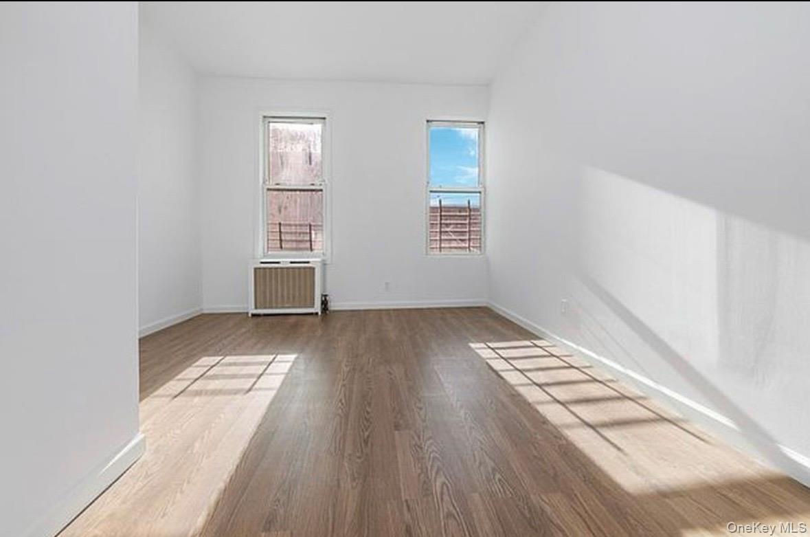 37-17 Greenpoint Avenue, Unit 2 Queens, NY 11101 - Photo 7 of 8 an empty room with wooden floor and windows