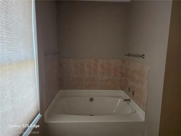 a bathroom with a granite countertop sink vanity mirror and toilet