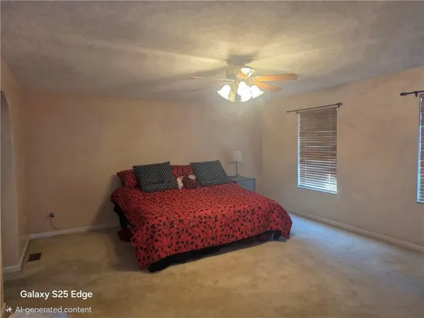a view of an empty room with window and chandelier fan