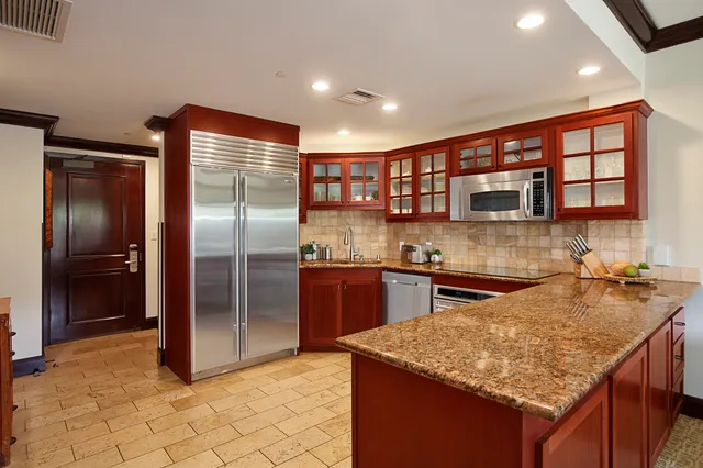 a kitchen with stainless steel appliances granite countertop a sink stove and refrigerator