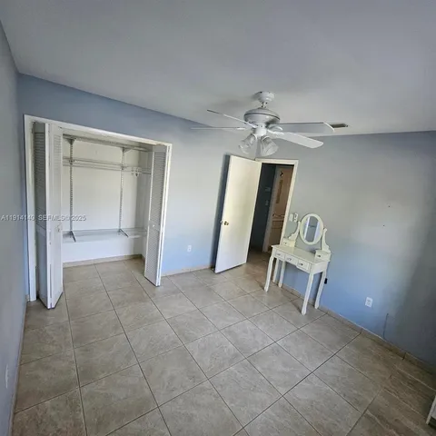 an empty room with a mirror and a fan