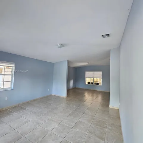 an empty room with a empty space and windows