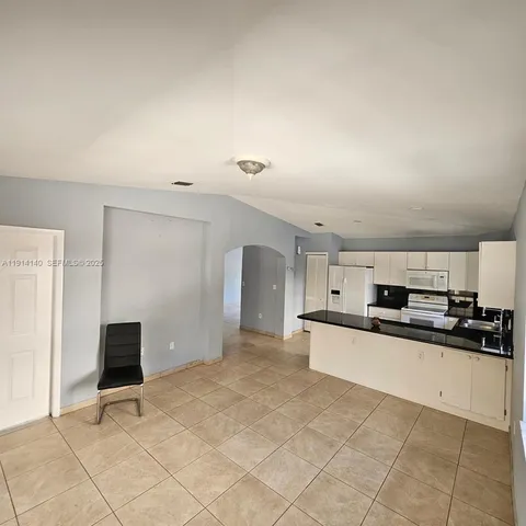 a kitchen with granite countertop a refrigerator and a stove top oven