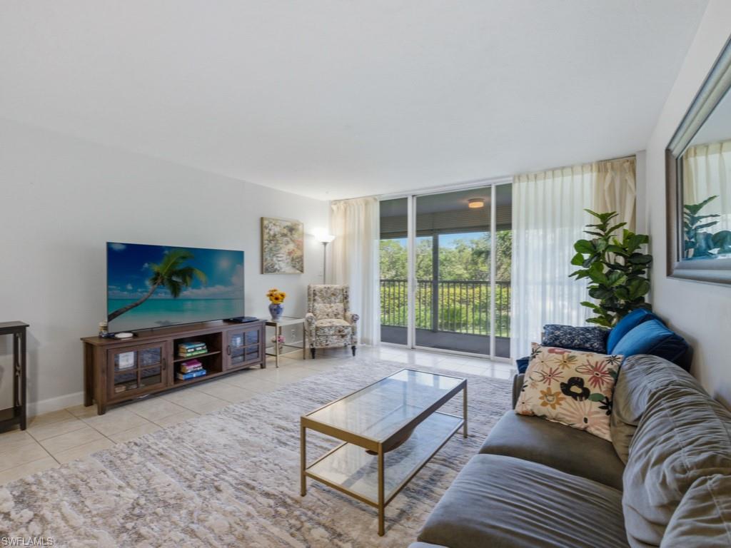 3 Bluebill Avenue, Unit 206 Naples, FL 34108 - Photo 3 of 19 a living room with furniture and a flat screen tv