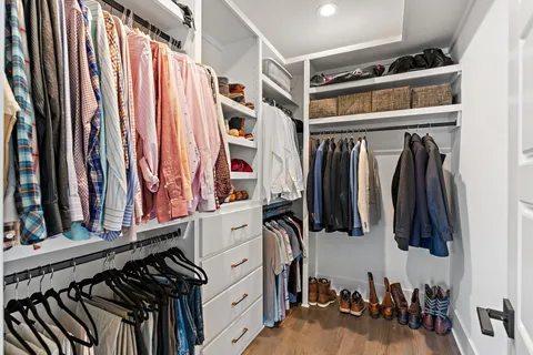 a view of walk in closet with clothes and shoes