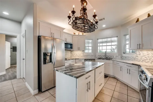 a kitchen with stainless steel appliances granite countertop a sink a stove cabinets and refrigerator