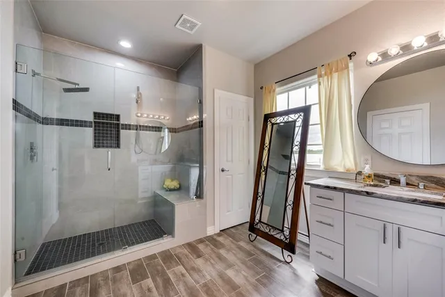 a bathroom with double vanity and a shower