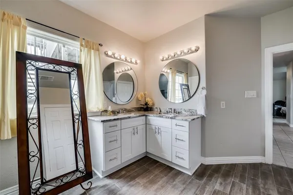 a bathroom with a granite countertop sink a mirror and a shower