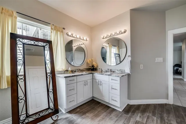 a bathroom with a granite countertop sink a mirror and a shower