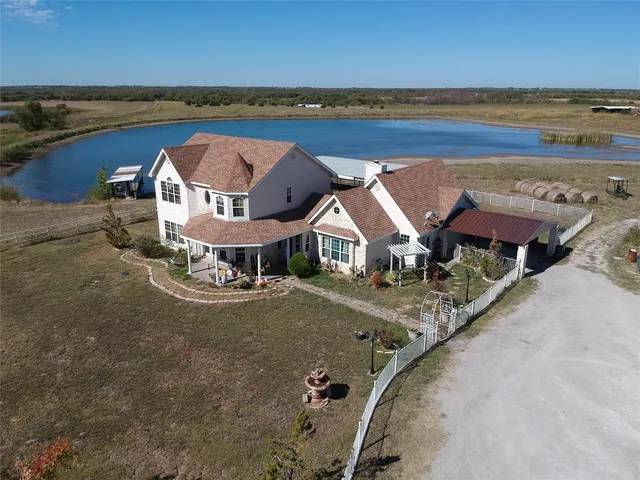 an aerial view of a house with outdoor space and ocean view