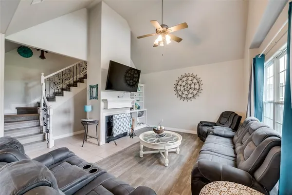 a living room with furniture a fireplace and a flat screen tv