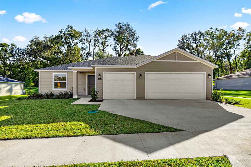 4597 Southwest 81st Loop Ocala, FL 34476 - Photo 1 of 6 a front view of a house with a yard and garage