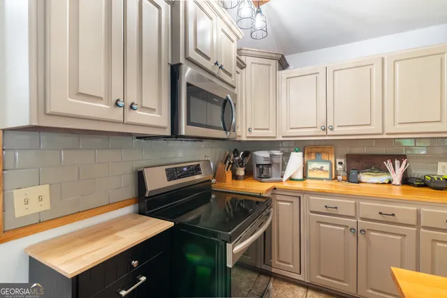 a kitchen with stainless steel appliances granite countertop a sink stove and cabinets