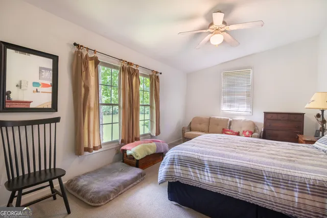 a bedroom with a bed a couch and a window