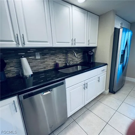 a kitchen with stainless steel appliances granite countertop a refrigerator and cabinets