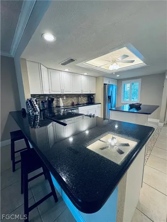a kitchen with stainless steel appliances granite countertop a sink a stove counter space and chairs