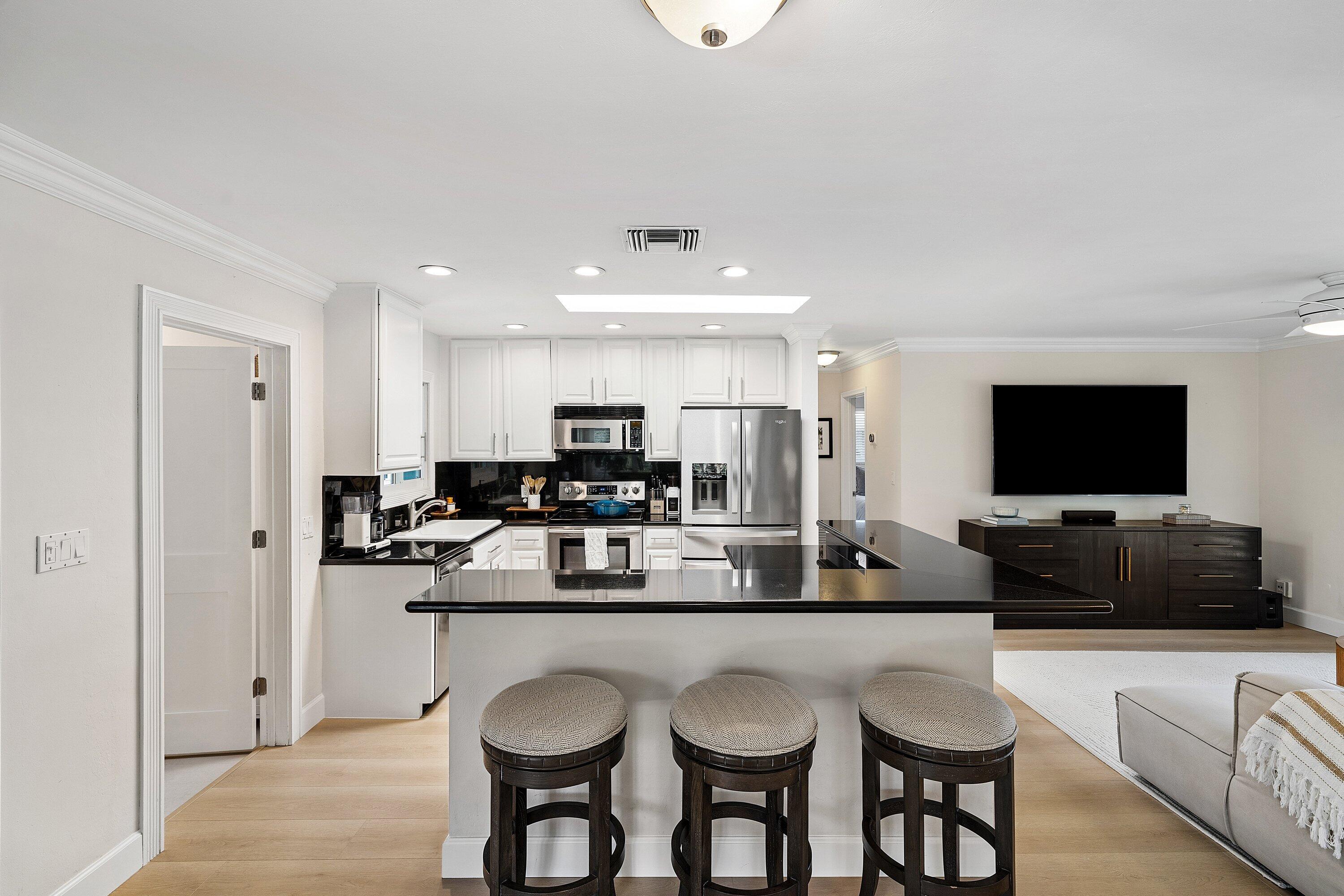 774 Southwest 7th Street Boca Raton, FL 33486 - Photo 12 of 28 a living room with stainless steel appliances kitchen island granite countertop a couch and a flat screen tv