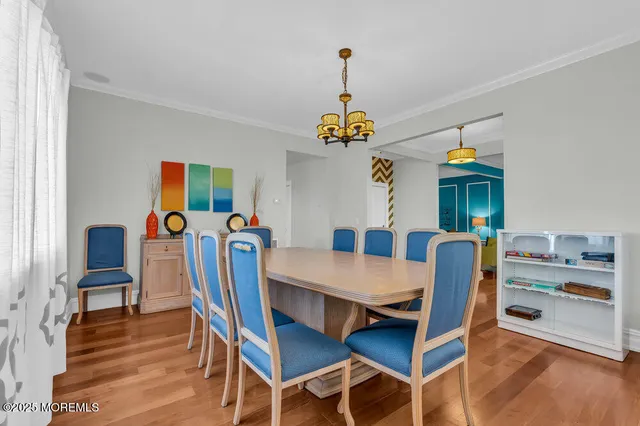 a kitchen with stainless steel appliances granite countertop a stove top oven a refrigerator and white cabinets with wooden floor