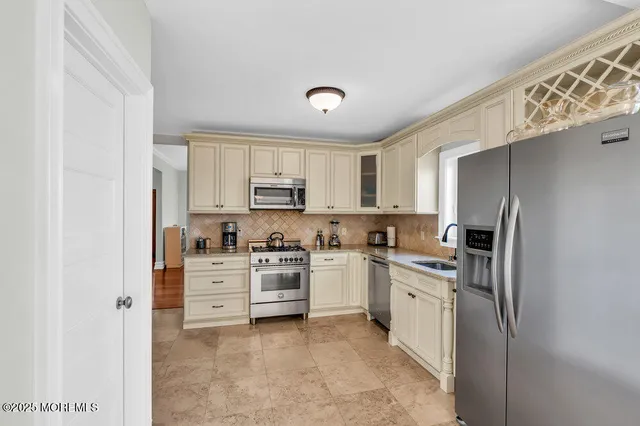 a kitchen with stainless steel appliances a refrigerator and a stove top oven