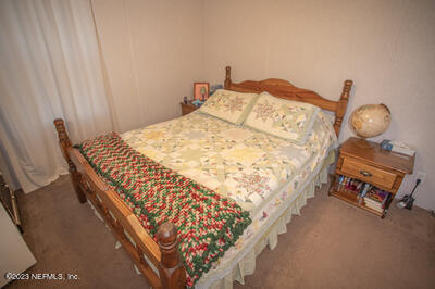 7169 Gas Line Road Keystone Heights, FL 32656 - Photo 18 of 31 a bedroom with bed and a chair