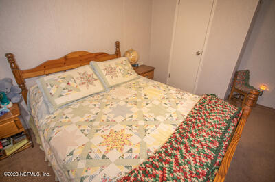 7169 Gas Line Road Keystone Heights, FL 32656 - Photo 19 of 31 a bedroom with a bed and a mirror