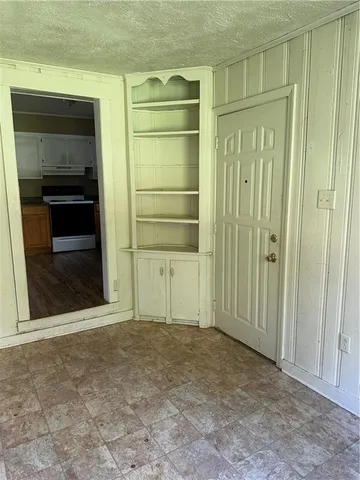 a view of an empty room with a fireplace and a cabinet