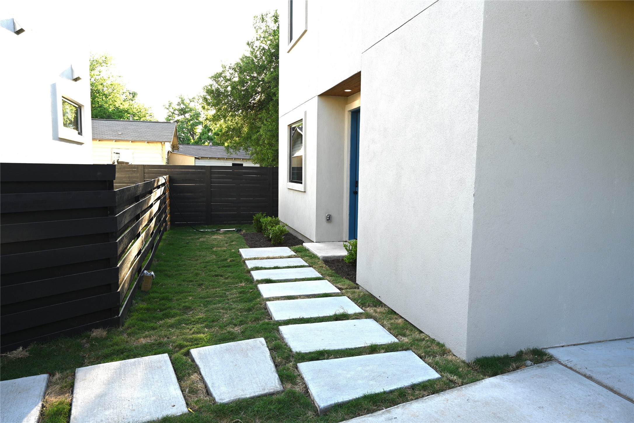 4410 Glomar Avenue, Unit 2 Austin, TX 78721 - Photo 3 of 24 The property features a walkway of square stepping stones set in a lawn, leading to entrance door
