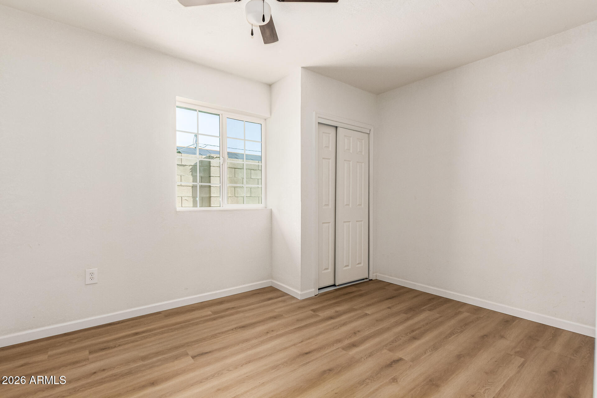 411 West Bealey Avenue Coolidge, AZ 85128 - Photo 14 of 26 an empty room with wooden floor fan and windows