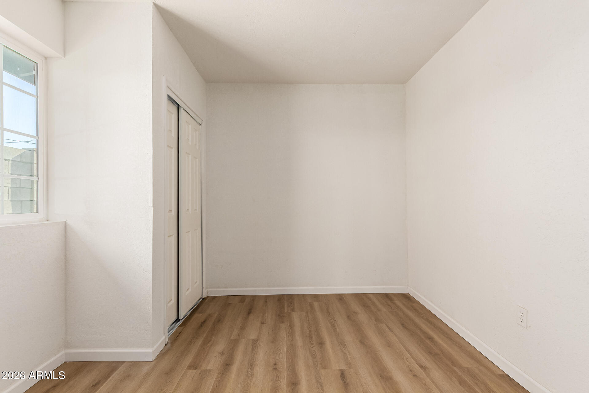 411 West Bealey Avenue Coolidge, AZ 85128 - Photo 15 of 26 a view of an empty room with wooden floor and a window