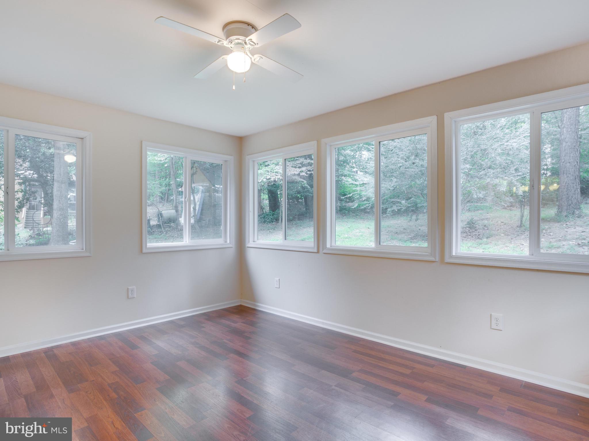 11893 Little Cove Point Road Lusby, MD 20657 - Photo 15 of 18 a view of an empty room with a window and wooden floor